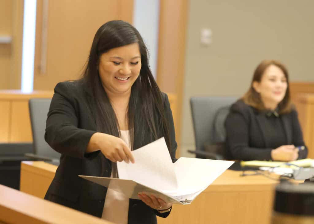 San Diego Inn of Court Workshop practice A woman reads from a file during a San Diego Inn of Court Workshop practice