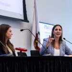 Two women talking on stage during a Trial Program lecture
