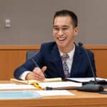 An attorney smiling at a desk in a courtroom