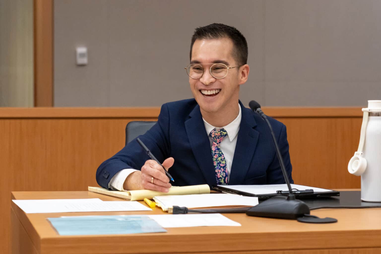 An attorney smiling at a desk in a courtroom