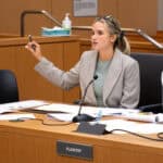 An attorney at the plaintiff desk in a courtroom, making an argument.